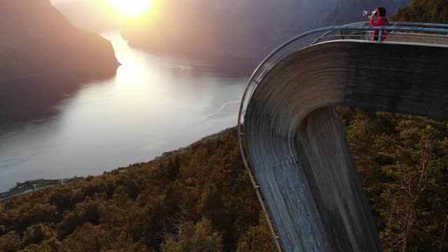 Tourist-enjoying-fjord-view-on-Stegastein-viewpoint-Norway