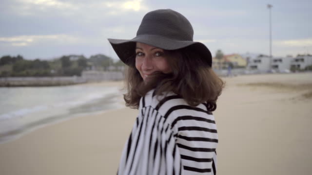 Attractive-positive-mature-lady-in-grey-hat-looking-at-camera.