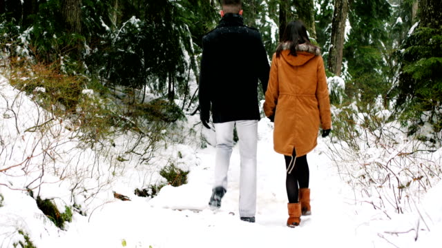 Pareja-caminando-en-el-sendero-cubierto-de-nieve-en-el-bosque