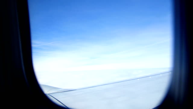 View-from-the-airplane-window.-The-sky,-clouds,-wing-of-an-airplane-can-be-seen.-The-weather-is-clear,-it-is-a-sunny-day