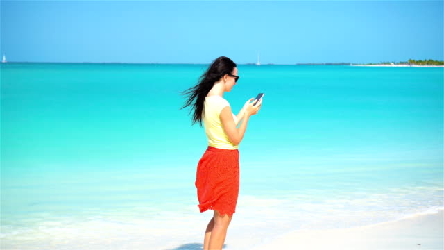 Teléfono-de-uso-joven-durante-las-vacaciones-de-playa-tropical.-Turístico-con-móvil-smartphone.
