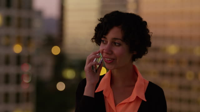 Woman-talking-on-phone-at-night-in-city