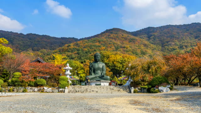 Lapso-de-tiempo-de-otoño-estatua-de-Buda-en-el-templo,-Korea.Zoom-de-Seúl-en