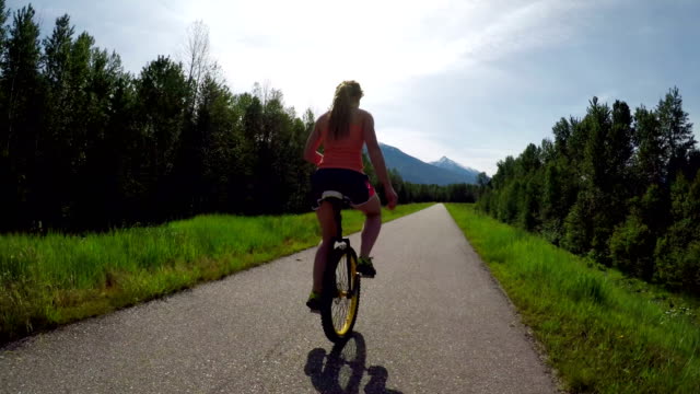 Woman-riding-unicycle-on-the-road-4k