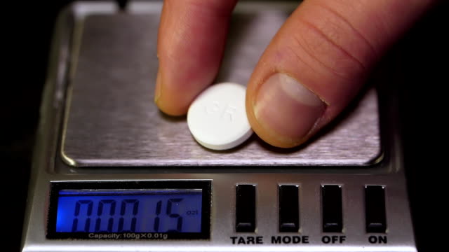 Close-up-of-electronic-scales-being-in-use.-Laboratory-scales.-Laboratory-worker-weighs-the-manufactured-tablets-on-the-control-scales.-Pills-and-medication-health,-close-up