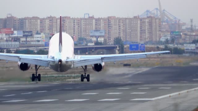 jet-landing-at-airport-runway,-rear-view