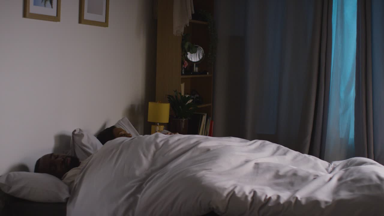 Free stock video Restless couple lying asleep in bed at home at night