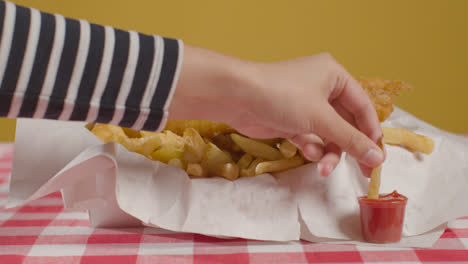 People-Using-Fingers-To-Eat-Traditional-British-Takeaway-Meal-Of-Fish-And-Chips-With-Ketchup-1