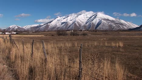 Lange-Aufnahme-Von-Schneebedeckten-Bergen-Und-Trockenen-Braunen-Feldern-Im-Südlichen-Utah