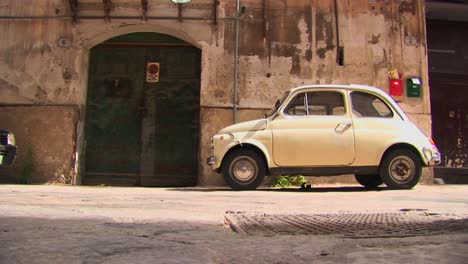 A-small-car-parked-outside-an-old-stone-building-Palermo-Italy