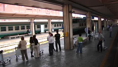Los-Pasajeros-En-Una-Estación-De-Tren-Se-Preparan-Para-Embarcar-En-Palermo,-Italia