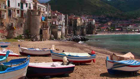 Boats-on-a-beach-next-to-the-ocean-and-houses-in-Cefalu-Italy---2