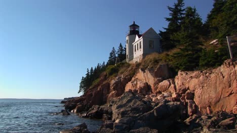 A-lighthouse-on-the-edge-of-a-cliff-overlooking-the-ocean-in-Bass-Harbor-Lighthouse-Maine-2