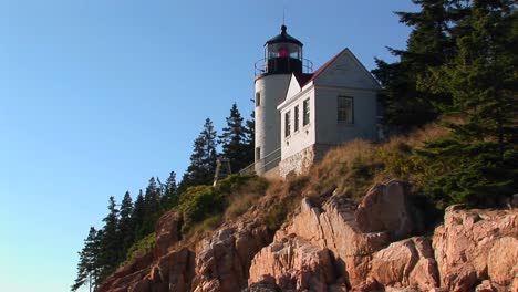 A-lighthouse-on-the-edge-of-a-cliff-overlooking-the-ocean-in-Bass-Harbor-Lighthouse-Maine-3