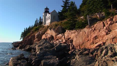 A-lighthouse-on-the-edge-of-a-cliff-overlooking-the-ocean-in-Bass-Harbor-Lighthouse-Maine-4