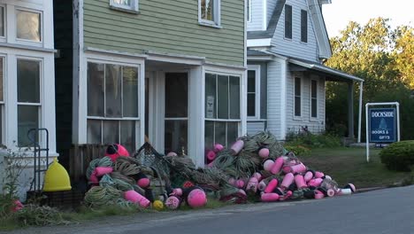 Fishing-nets-and-buoys-are-in-piles-outside-a-building-at-a-lobster-village-in-Stonington-Maine