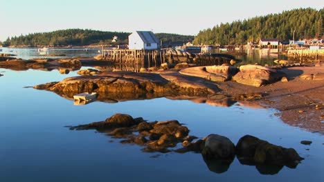A-lobster-village-building-over-water-as-seen-from-a-rocky-shore-in-Stonington-Maine