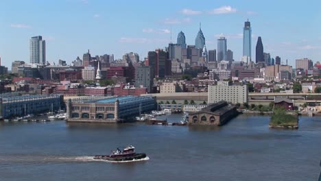 A-boat-passes-by-the-Ben-Franklin-Bridge-that-leads-to-Philadelphia-Pennsylvania-