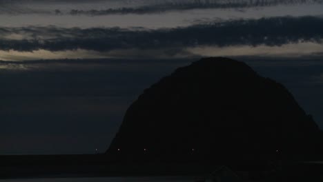 A-time-lapse-shot-over-a-dark-round-mountain-at-Morro-Bay-California