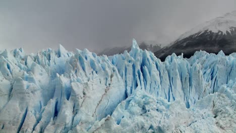 The-spiked-tops-of-a-glacier-stand-against-rugged-mountains-1