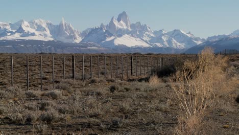 Schwenk-über-Eine-Umzäunte-Region-Im-äußersten-Süden-Patagoniens-Mit-Dem-Fitzroy-Gebirge-Im-Hintergrund
