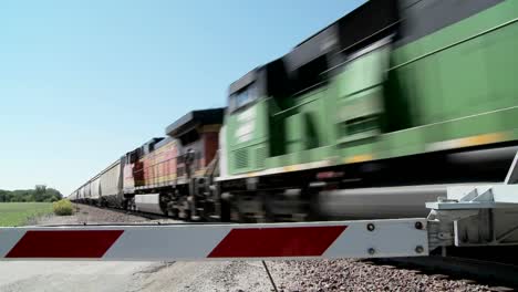 A-freight-train-speeds-past-a-gated-railroad-crossing