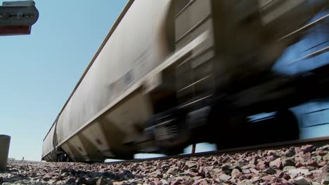 Low-angle-of-a-train-passing-with-roadbed-in-foreground-2
