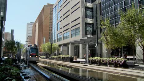 A-rapid-transit-train-moves-quickly-through-downtown-Houston-with-fountains-dancing-4