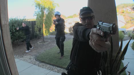 DEA-or-SWAT-officers-with-arms-drawn-pound-on-the-door-before-performing-a-drug-raid-on-a-house-1