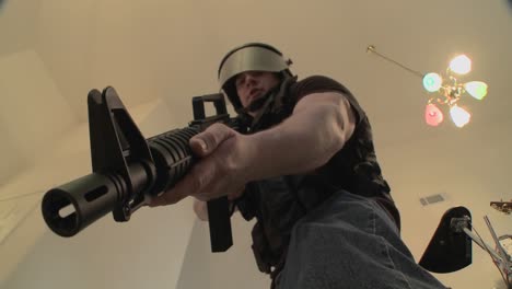 A-SWAT-team-with-DEA-officers-clears-a-house-during-a-drug-raid-and-holds-a-suspect-at-gunpoint