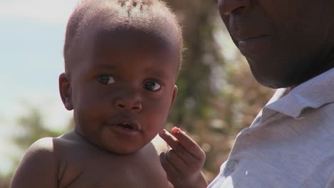 A-man-holds-a-small-baby-in-Africa