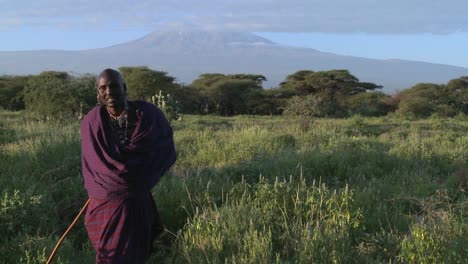A-Masai-warrior-stands-in-front-of-Mt-Kilimanjaro-in-Tanzania-East-Africa-at-dawn
