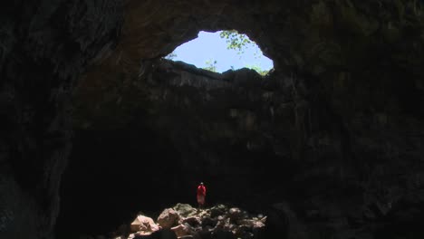 Spectacular-tilt-down-of-a-Masai-warrior-standing-in-a-cave-in-kenya