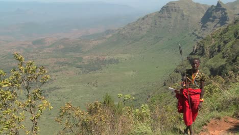 A-Masai-warrior-stands-at-the-edge-of-a-vast-canyon-in-Northern-Kenya