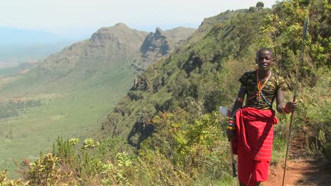 Tilt-up-to-reveal-a-Masai-warrior-standing-at-the-edge-of-a-vast-canyon-in-Northern-Kenya