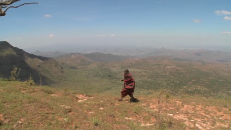 A-masai-warrior-walking-along-a-vast-landscape-in-Northern-Kenya