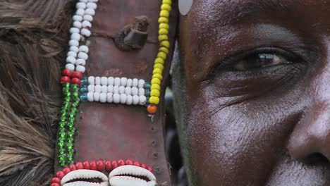 An-extreme-close-up-of-a-Masai-warrior-in-full-headdress-with-d=beads-and-beadwork