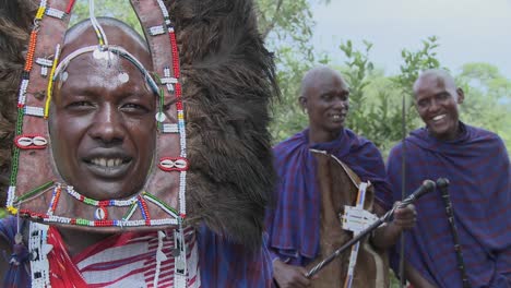 Masai-warrior-in-full-headdress-with-two-friends-nearby