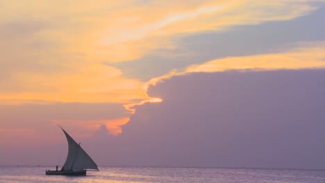 A-dhow-sailboat-sails-along-the-coast-of-Zanzibar-during-a-beautiful-tropical-sunset