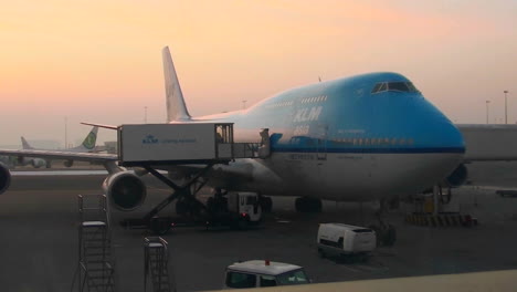 A-747-jet-sits-at-an-airport-boarding-gate-at-dusk-or-dawn