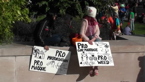 Two-girls-hold-signs-announcing-they-are-in-favor-of-masturbation-marijuana-mosques-and-gay-marriage