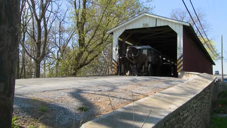 An-Amish-horse-and-buggy-cart-pass-through-a-covered-bridge-in-rural-Lancaster-Pennsylvania-1