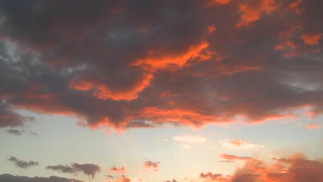 Bight-orange-light-reflects-off-time-lapse-clouds-at-sunset
