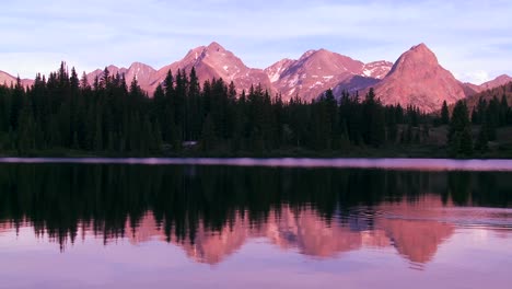 Las-Montañas-Rocosas-Se-Reflejan-Perfectamente-En-Un-Lago-Alpino-Al-Atardecer