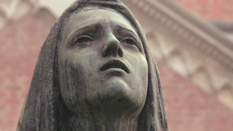 A-statue-of-a-woman-weeping-in-a-cemetery-or-church