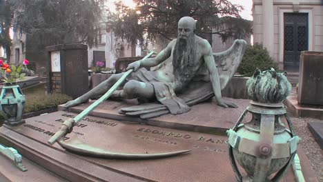 The-grim-reaper-sits-on-a-tomb-in-a-graveyard-with-his-scythe-1