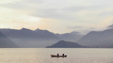 Two-fishermen-fish-from-a-boat-on-a-beautiful-lake-in-front-of-the-Italian-Alps-2