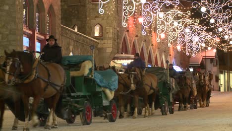 A-horse-drawn-carriage-makes-its-way-down-a-snowy-street-in-wintertime