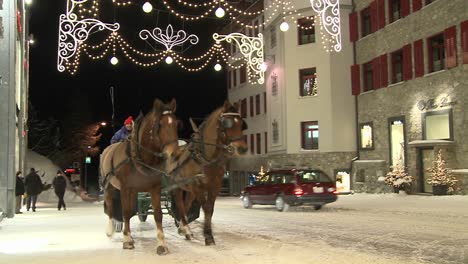 A-horse-drawn-carriage-makes-its-way-down-a-snowy-street-in-wintertime-1