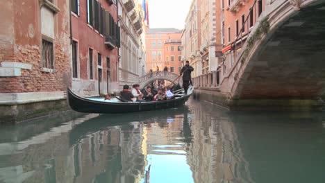 A-gondola-is-rowed-through-a-quiet-canal-in-Venice-Italy